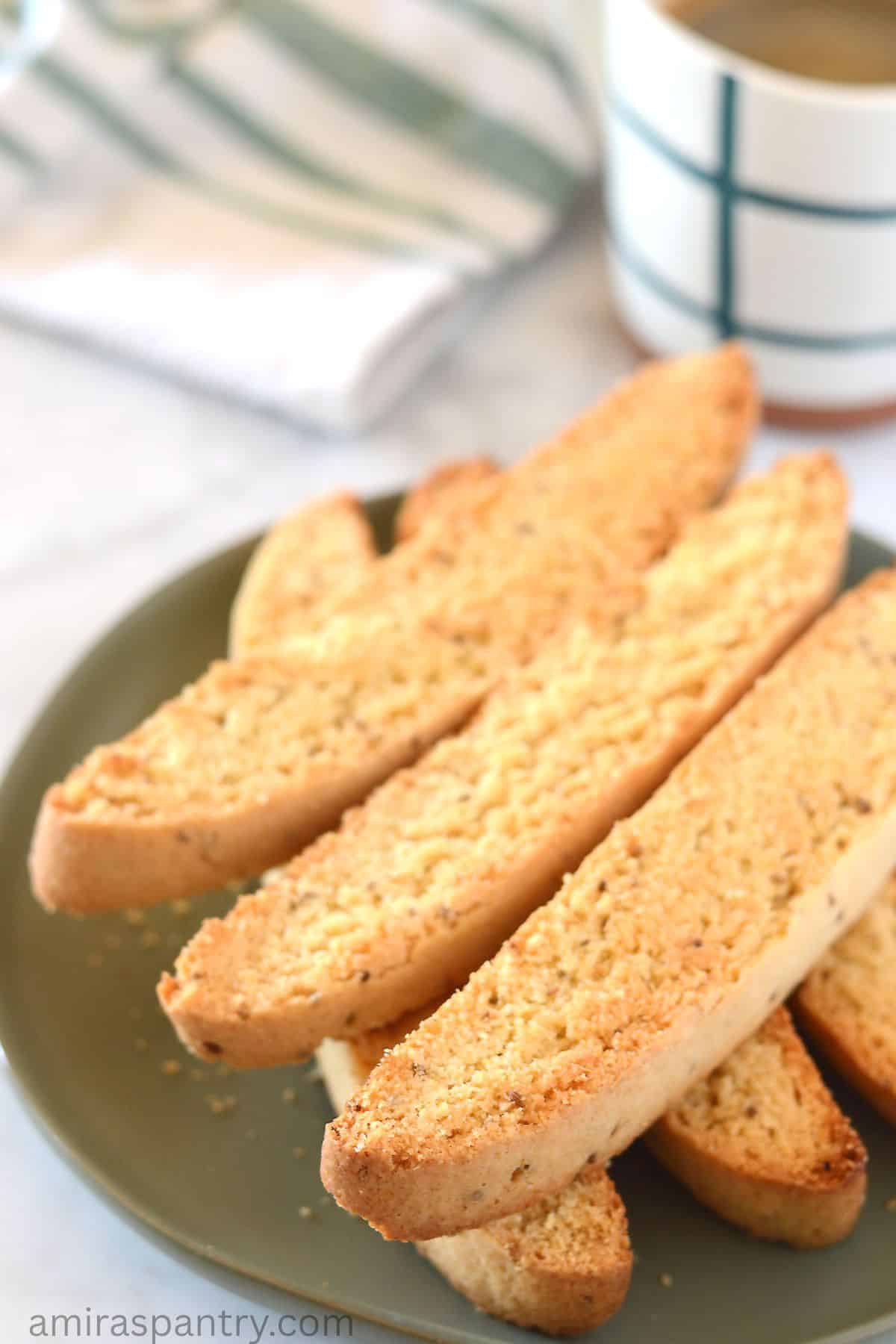 A stack of anise biscotti on a green plate.