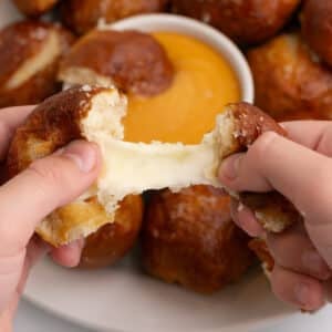 Tearing one pretzel ball to show melting cheese.