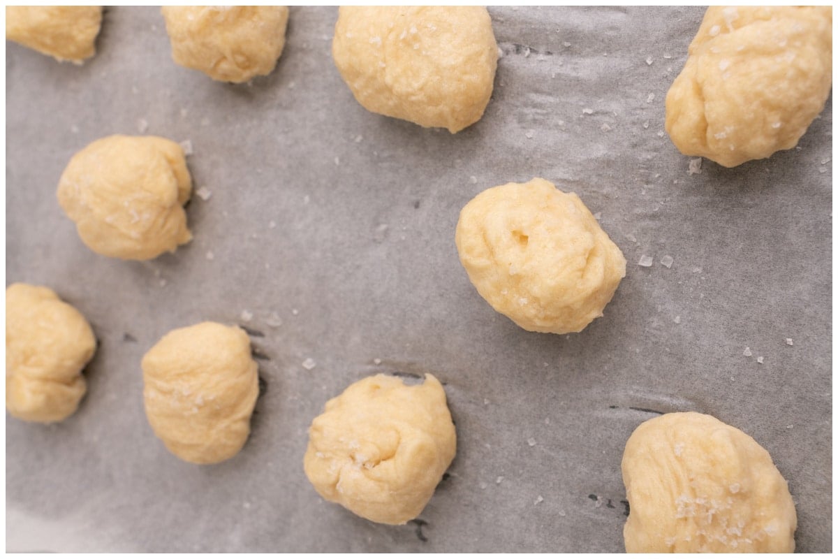 Pretzel dough balls on a baking sheet.