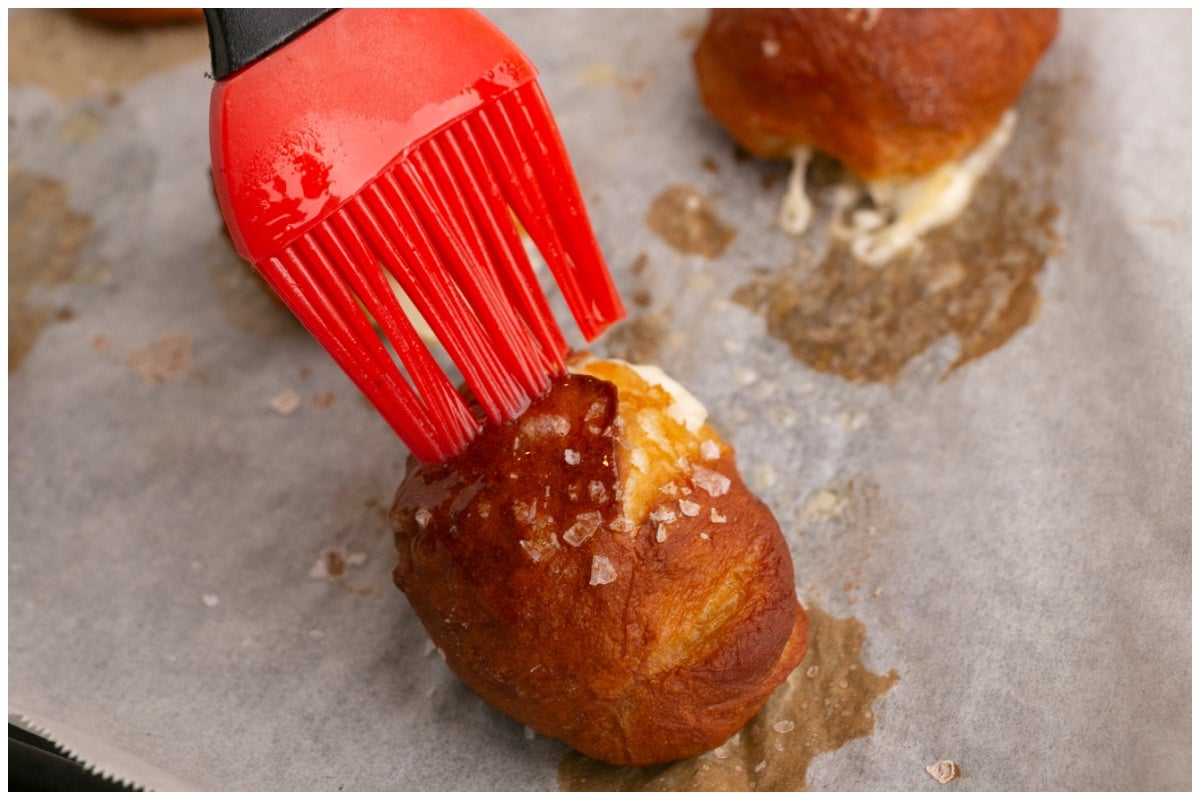 Brushing pretzel bites with melted butter.