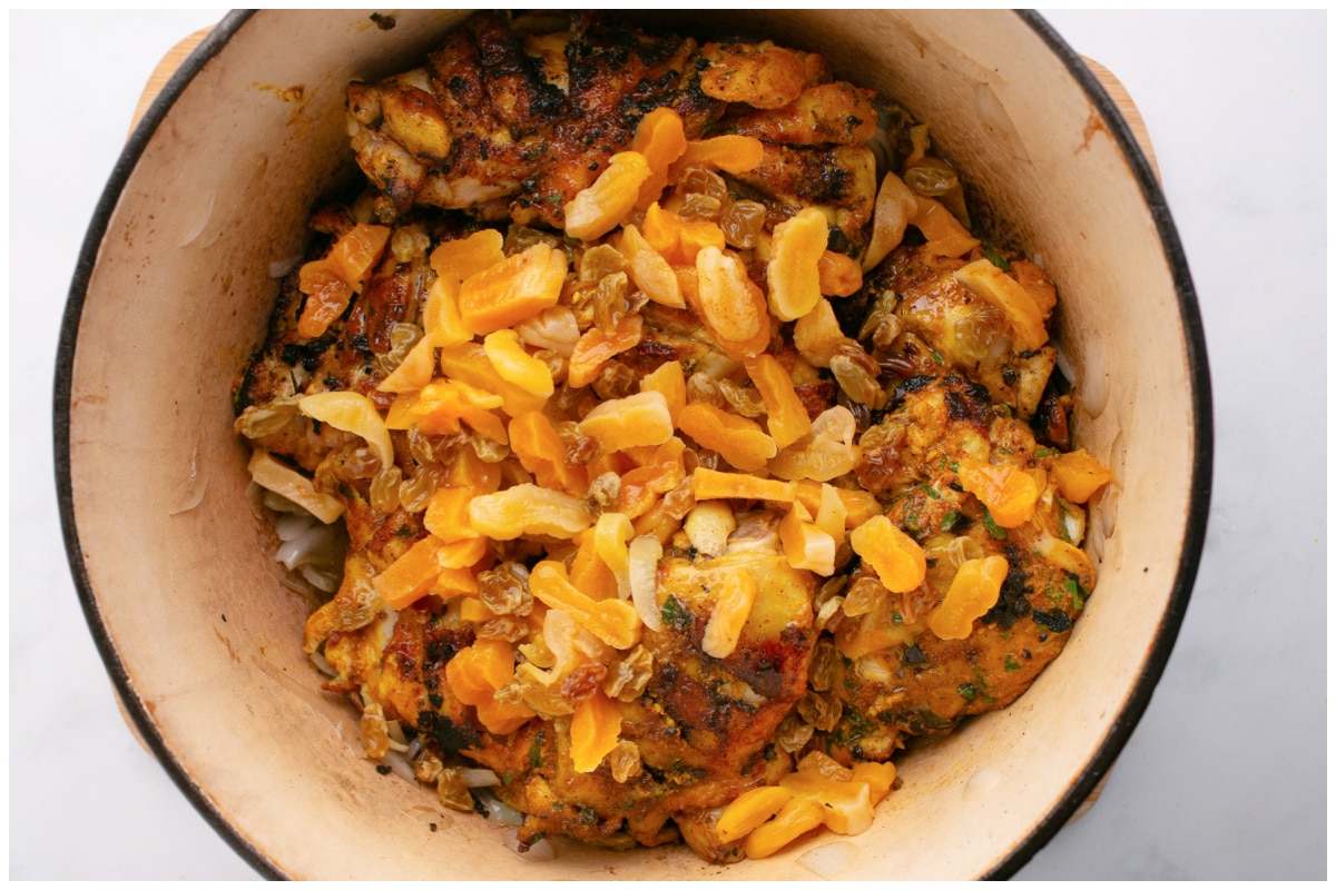 Chicken tagine ingredients cooking in a deep pot.