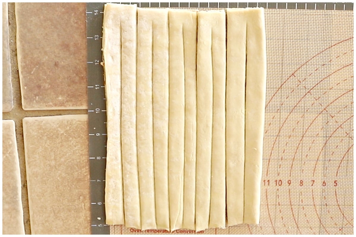 Puff pastry sheet cut on a baking mat.