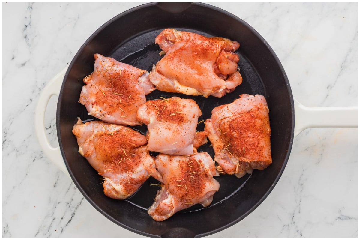Seasoned chicken being seared on a skillet.