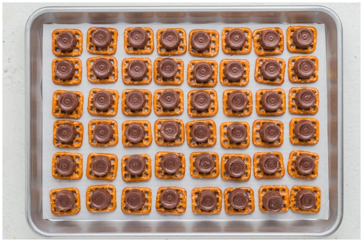 Pretzels on an baking sheet topped with rolo candy.