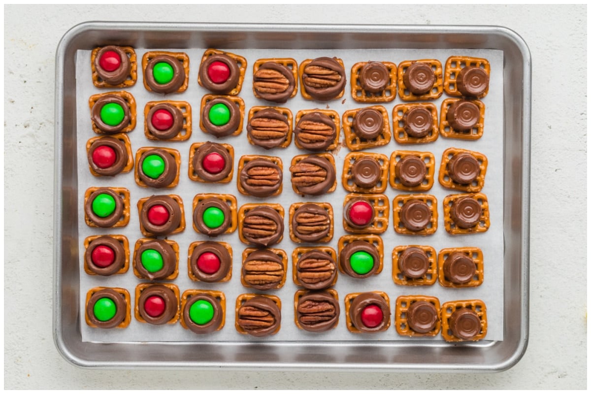 Melted Rolo on pretzels topped with oeacan halves and M&M candies.