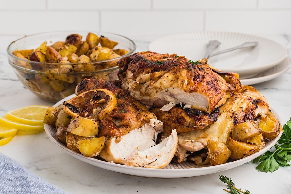 Cajun chicken breast on a white dinner plate with roasted potatoes.