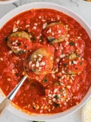An overhead image for a white bowl with eggplant meatballs.