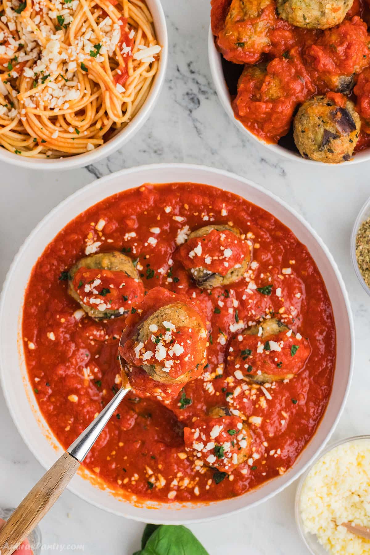 An overhead image of a large bowl with eggplant meatballs with marinara sauce.
