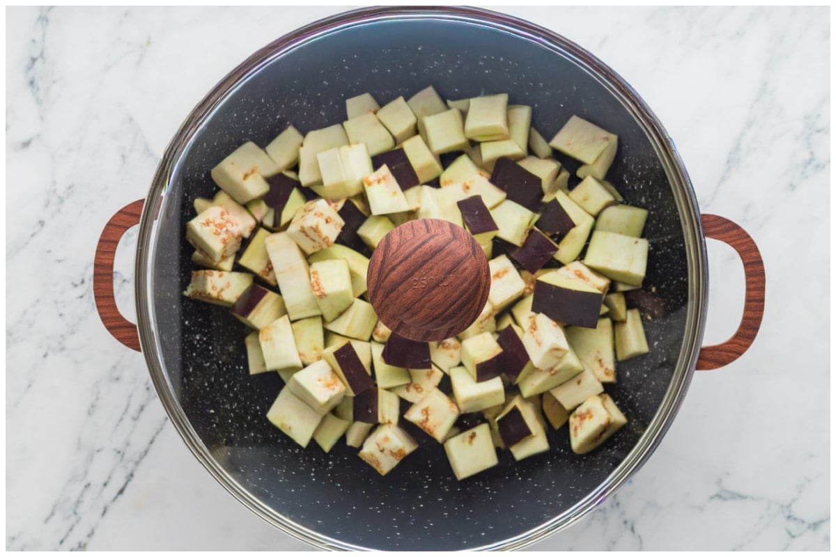A large skillet covered with eggplants.