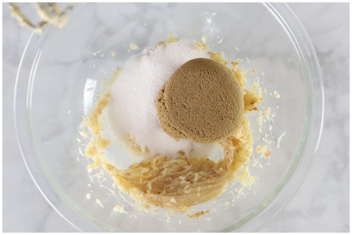 A glass bowl with browned butter, brown and granulated sugar.