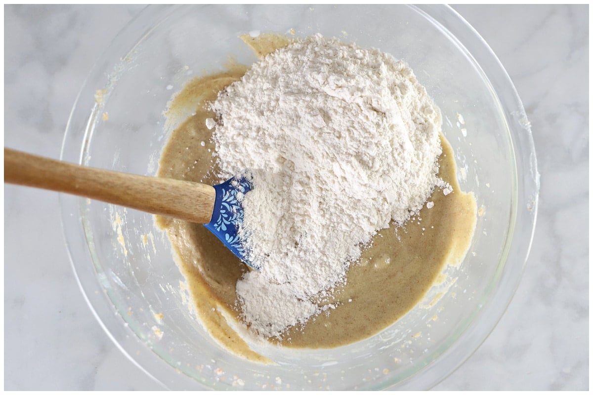 A glass bowl with the dry ingredients added to the wet cookie ingredients.