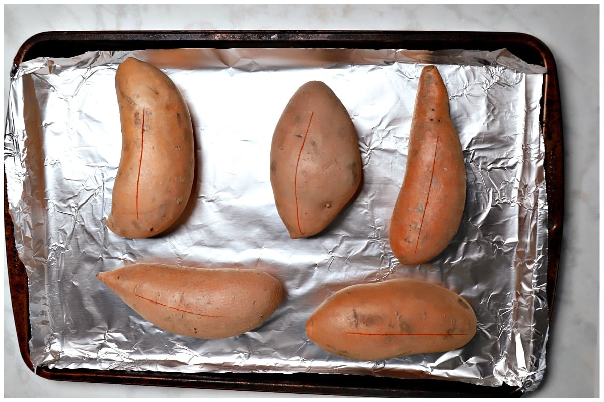 Sweet potatoes on a foil lined baking sheet.