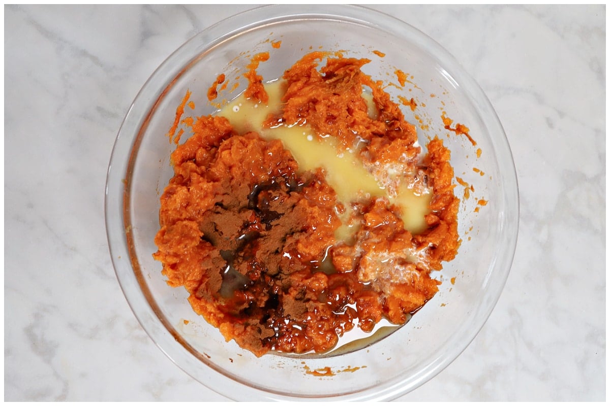 A glass bowl with whipped sweet potato ingredients.