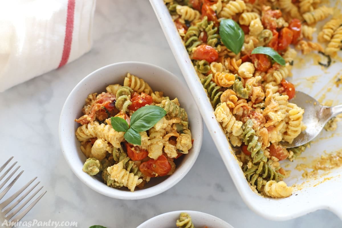Baked feta pasta in a white bowl garnished with fresh basil.