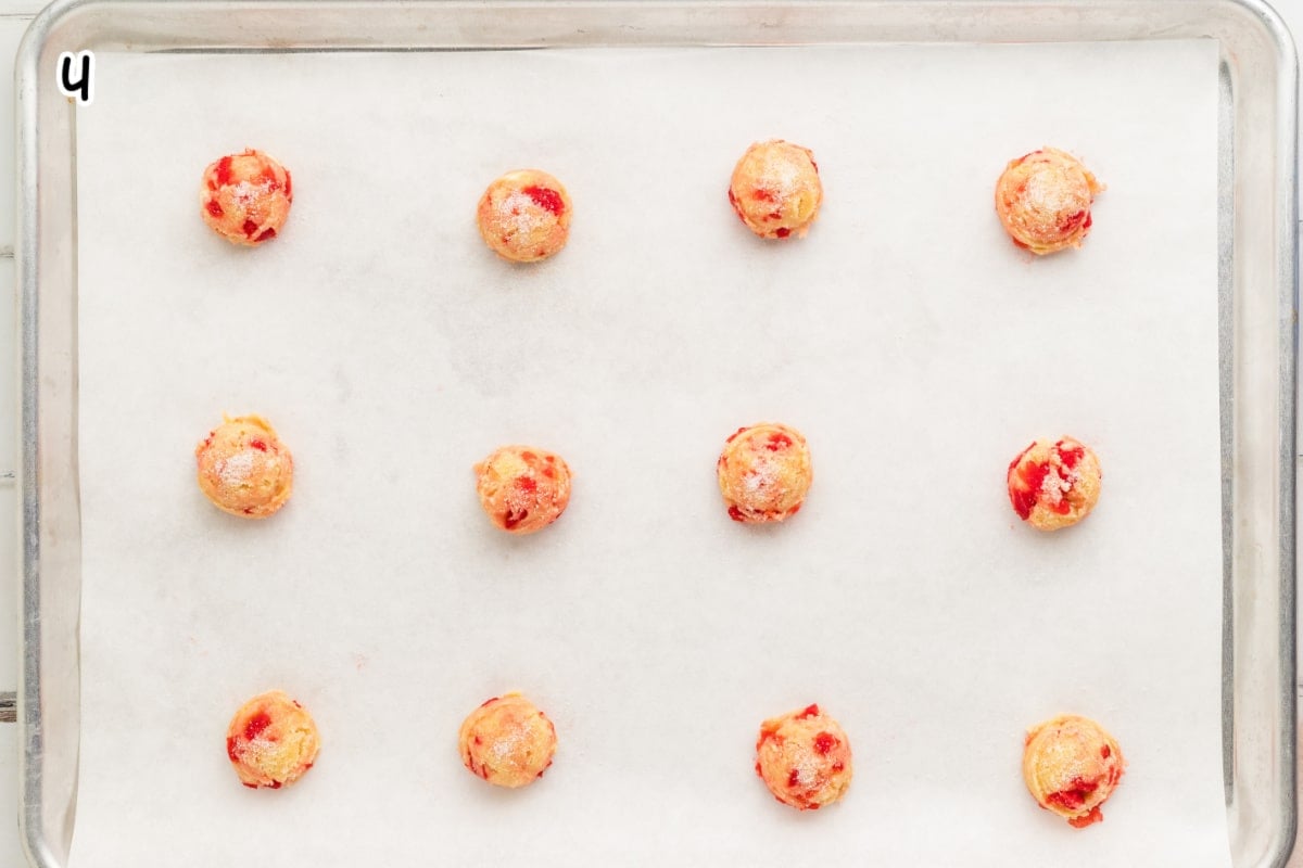 Cherry cookie dough balls on a baking sheet.