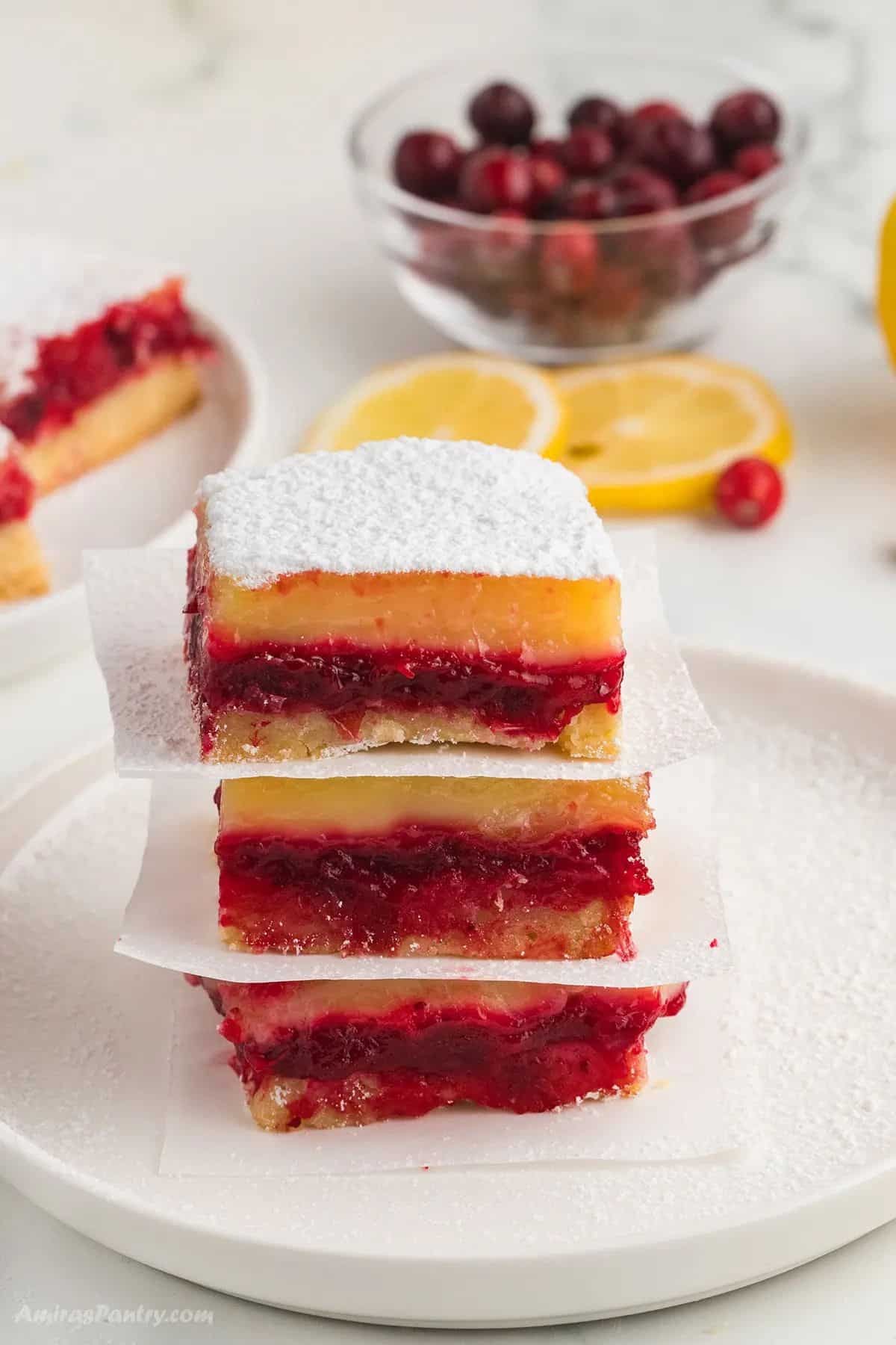 A stack of cranberry lemon bars on a white plate.