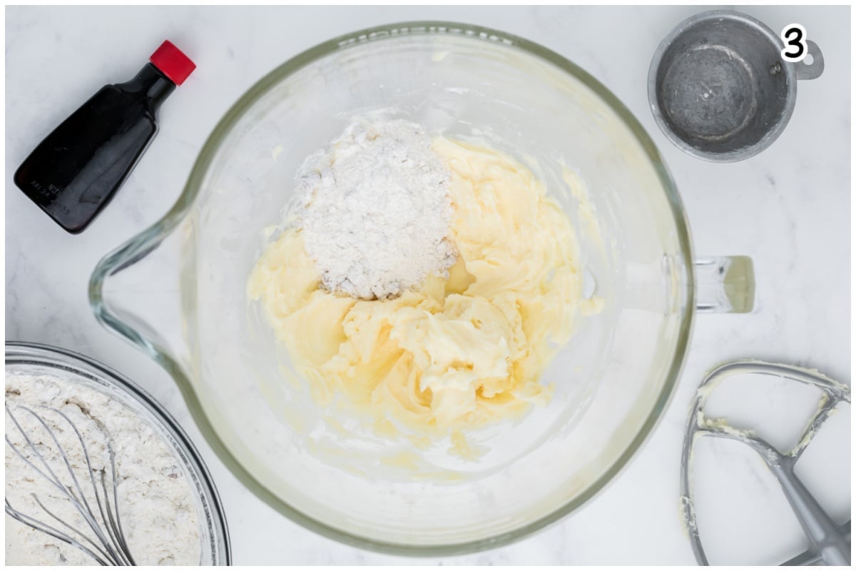A glass mixer bowl with creamed butter and sugar.