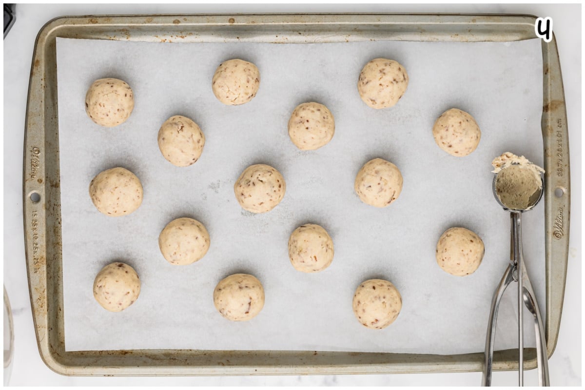 A large baking sheet with cookie balls.
