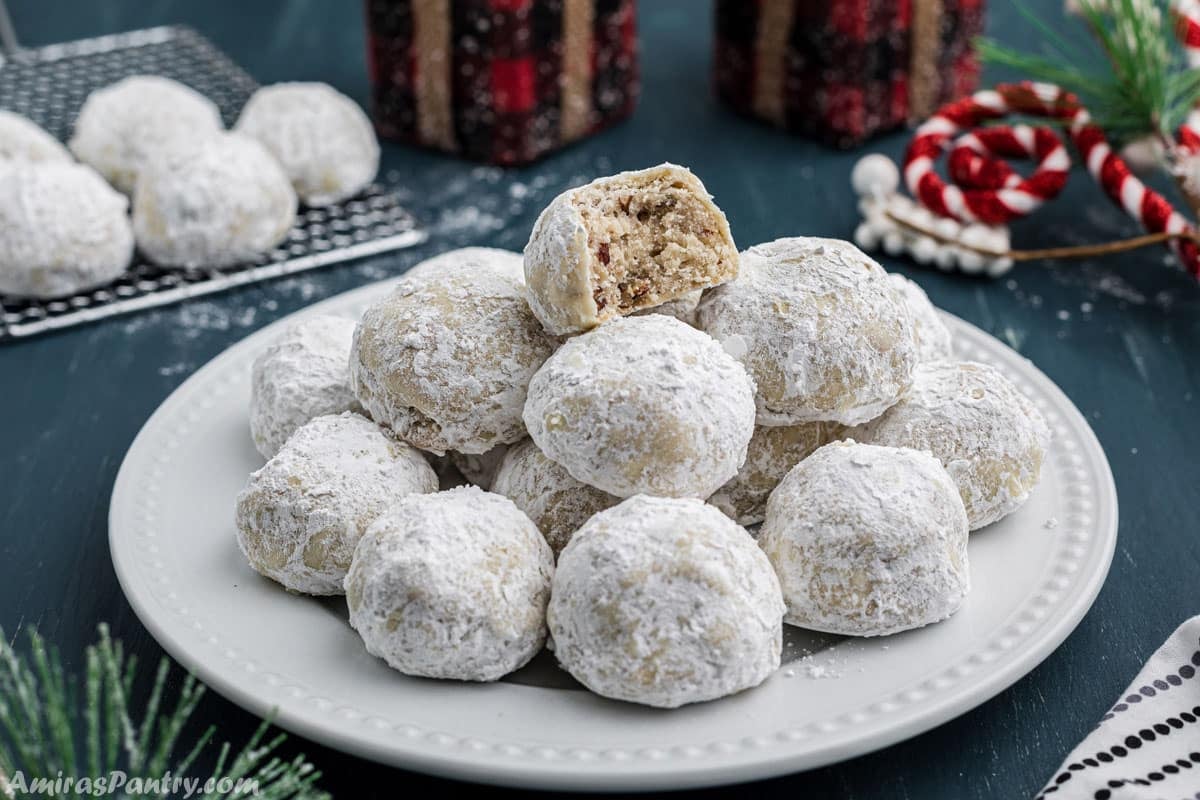 A white platter with a snowball cookies stack.