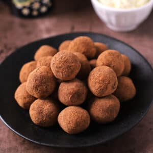 A black serving platter with a pile of tiramisu balls.