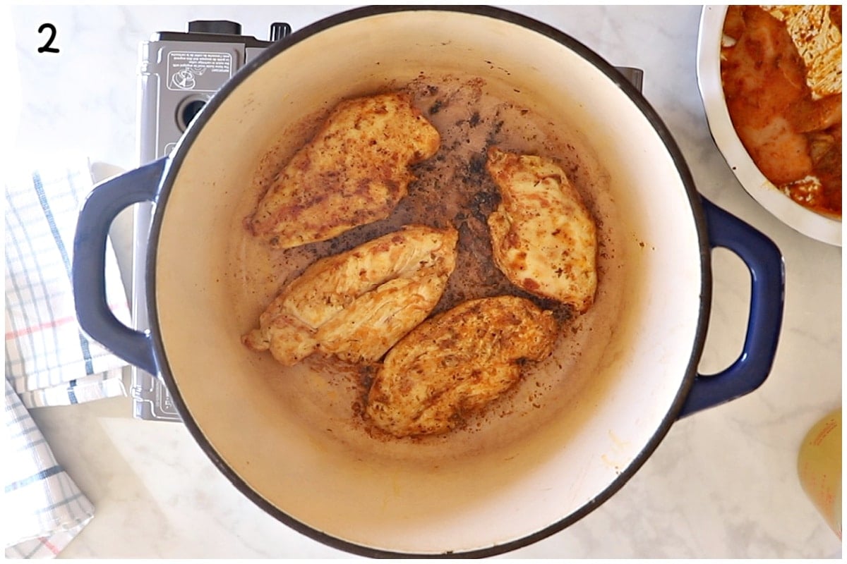 Searing chicken breasts in a large dutch oven.
