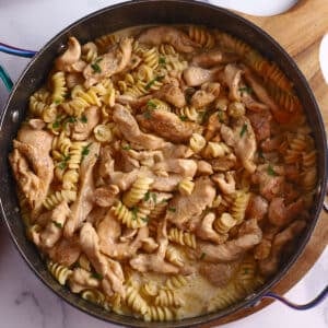 An overhead image of a skillet with cajun chicken pasta.