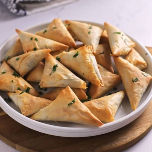 A close up image on a white plate with spanakopita.