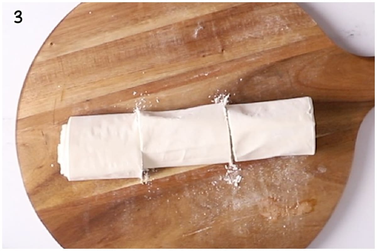 Phyllo sheet rolls on a wooden board.