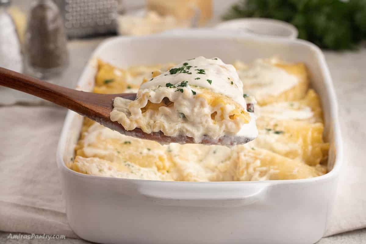 A close up image of a chicken lasagna roll on a serving spoon.