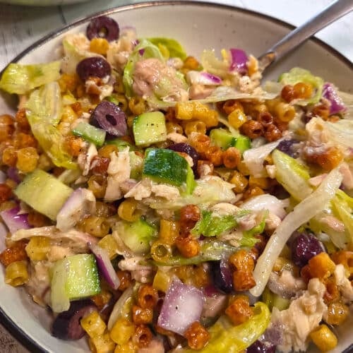 A close up image of a bowl with crispy pasta salad.