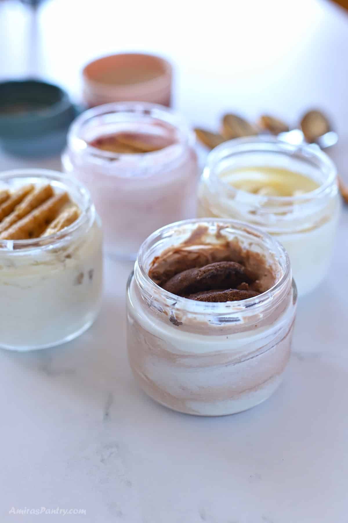 4 jars of different flavors of Japanese cheesecake viral recipe on a marble table.