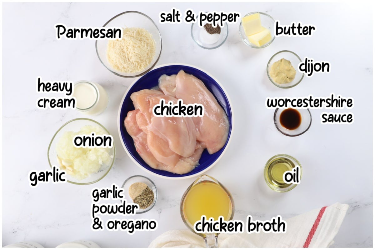 Overhead photo of ingredients for creamy Dijon chicken arranged in labeled bowls on a white surface.