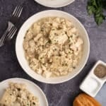 An overhead image of bowl of chicken and dumplings on a table.