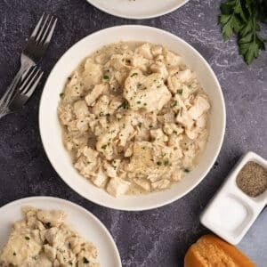 An overhead image of bowl of chicken and dumplings on a table.
