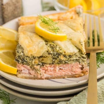 Close-up of a slice of Salmon Wellington with flaky puff pastry and tender pink salmon.