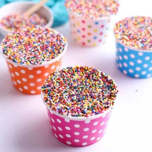 Close-up of viral Dot Cakes in colorful polka dot cups, each topped with frosting and covered in rainbow sprinkles.