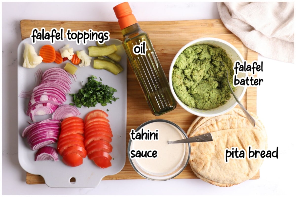 Overhead view of falafel taco ingredients on a wooden cutting board.