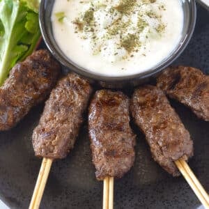 An overhead image of kofta on a black platter.