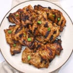 An overhead image of a platter with soy sauce chicken garnished with chopped green onion.