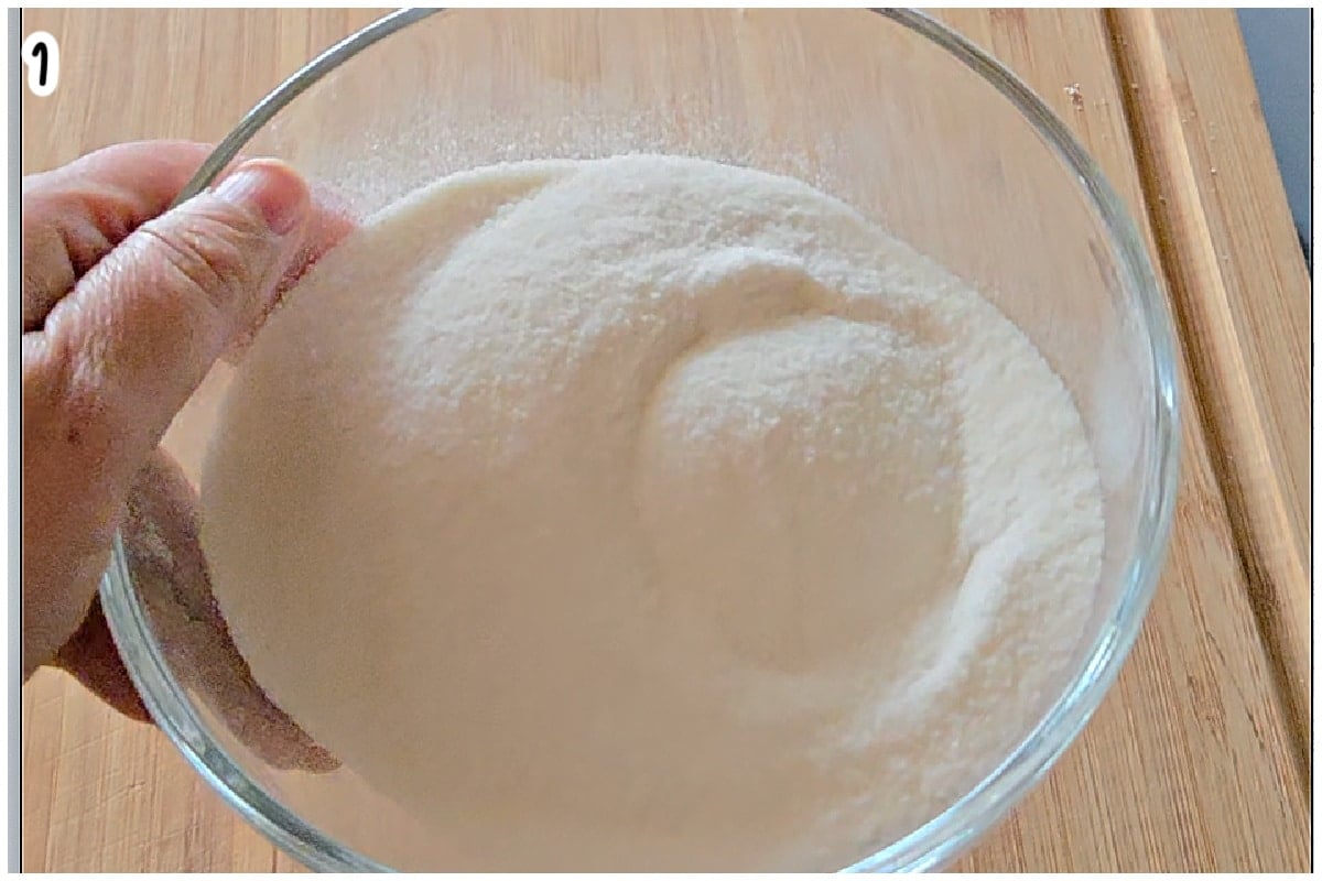 A hand holding a glass bowl with ground rice.