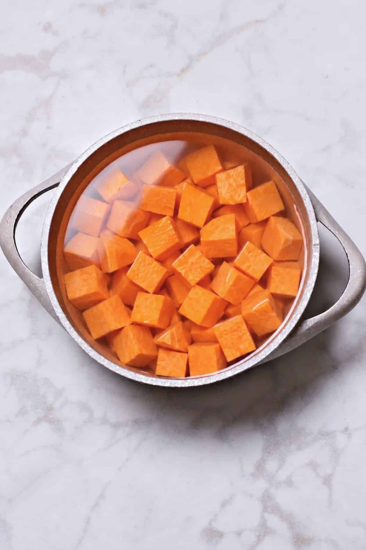 Boiling sweet potato cubes.